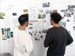 Product Design Students discussing project on wall